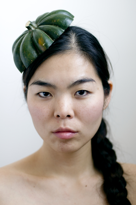 portrait of a woman wearing the top of squash as a hat