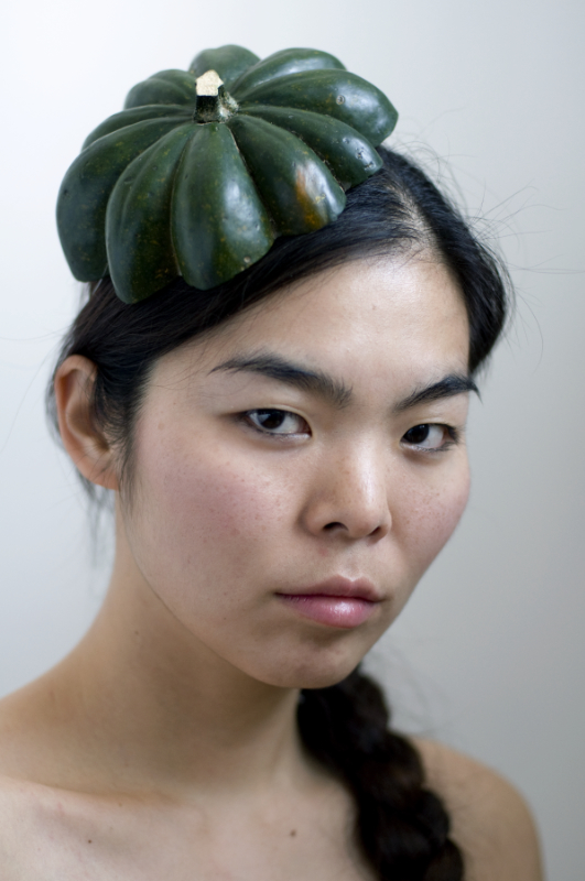portrait of a woman wearing the top of squash as a hat