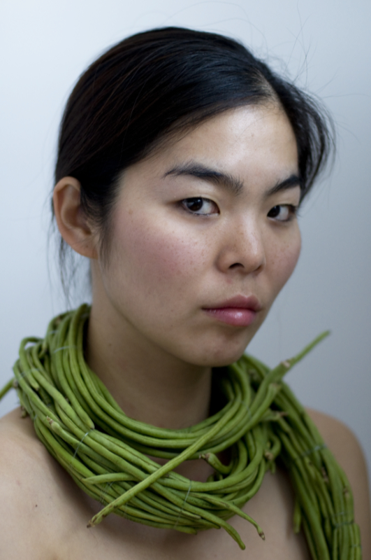 portrait of a woman wearing a scarf made out of long beans