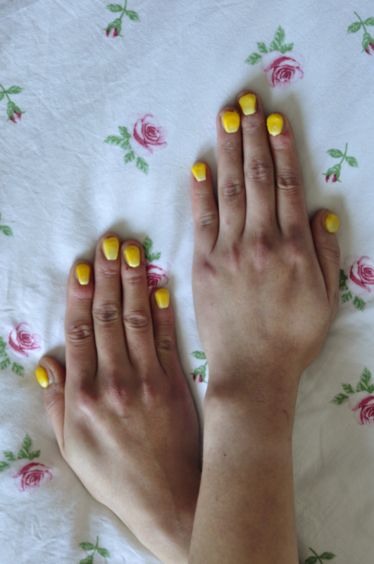 close up image of a woman's hands with corn niblets on top of her fingernails
