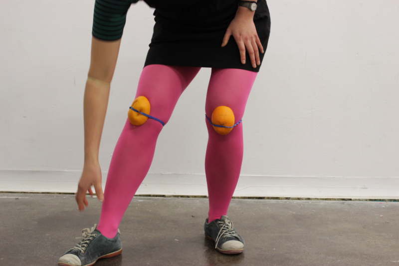 close up of a woman bending down wearing oranges as kneepads