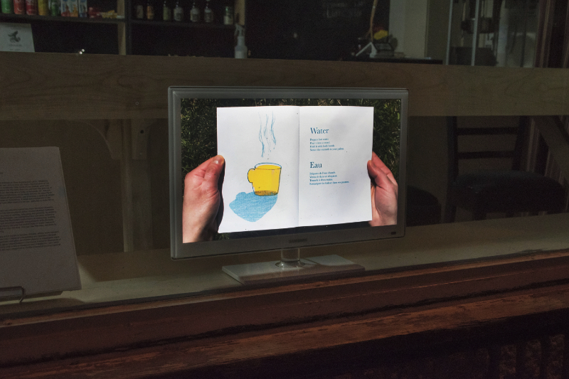 still frame of video of hands holding a booklet playing on a television