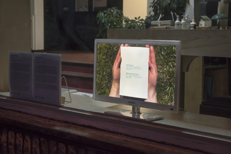 still frame of video of hands holding a booklet playing on a television